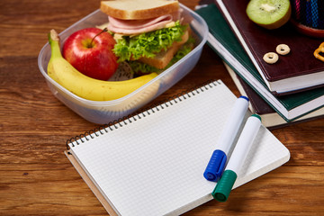 A notebook, two markers and assortment of cookies on a wooden table, copy space for text, selective focus.