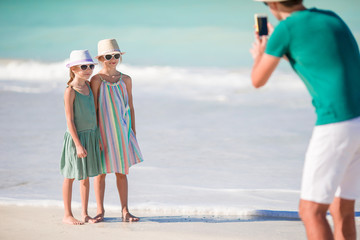Man taking a photo of his kids on the beach