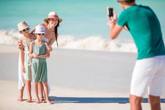 Family of four taking a selfie photo on their beach holidays.