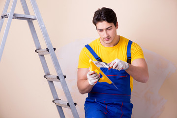 Young contractor employee applying plaster on wall