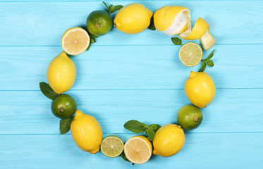 Naklejka na ściany i meble Lemons and lime on a blue background frame. With space for text