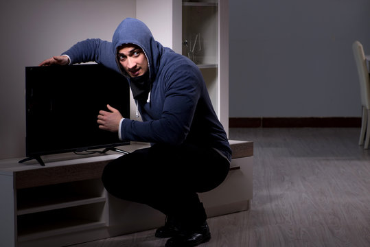 Burglar thief stealing tv from apartment house