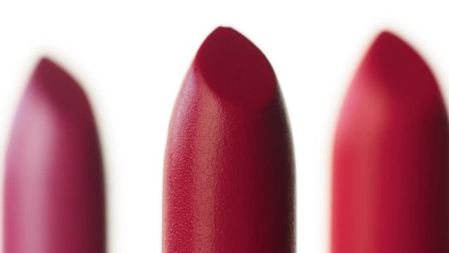 macro shoot of lipstick Three lipstick moving on white background