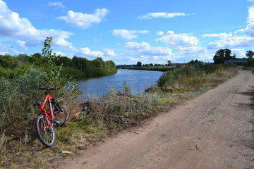 Fototapeta premium river,road and red bicycle