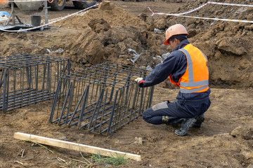 workers at the construction site make a framework of reinforcement