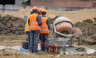 workers at the construction site mix concrete
