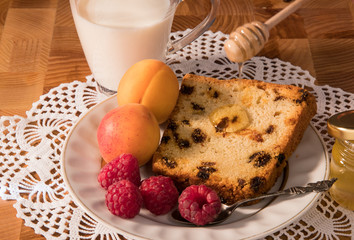 breakfast on a white plate milk in a cup cupcake honey and raspberry