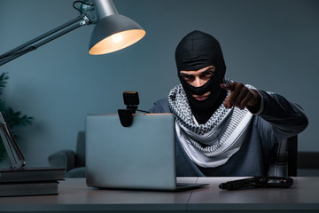 Hacker wearing balaclava mask hacking computer