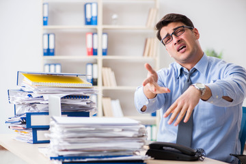 Extremely busy businessman working in office