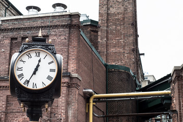 Analog Clock with brick buildings in the background