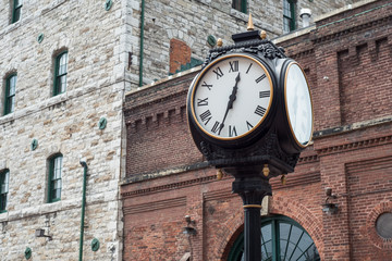 Analog Clock with brick buildings in the background