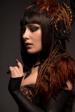 Portrait of brunette woman with dark gothic makeup and creative hairstyle