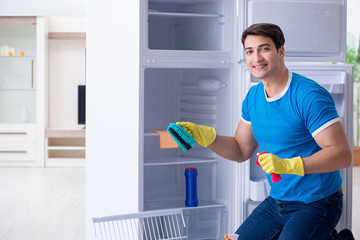 Man cleaning fridge in hygiene concept