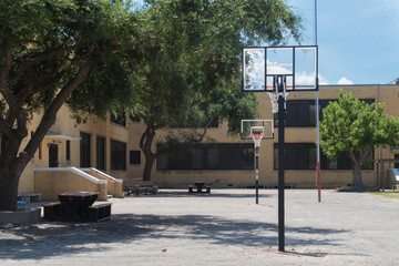 an empty school yard and two basketball goals