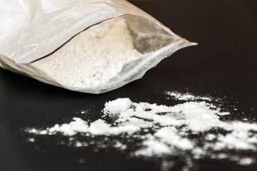 Drugs in a plastic bag on black background. Narcotic drugs addicted.