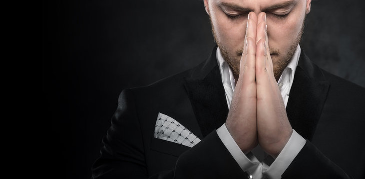 Portrait of businessman praying or thinking.