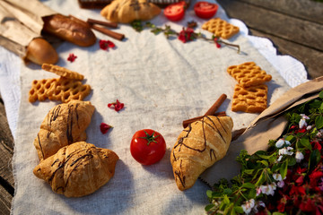 Picnic on a green lawn, pastries and vegetables on a homespun tablecloth, summer season, flat lay, selective focus