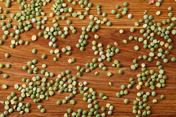 Green peas on rustic wooden background, close-up, top view, selective focus.
