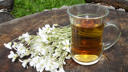 Fragrant floral tea on a wooden background.