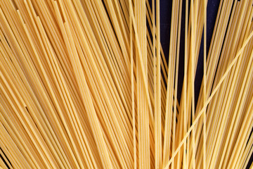Close up of a raw dry Italian pasta spaghetti on a black board