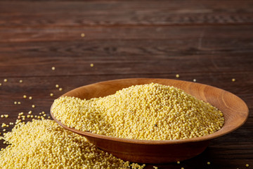 Lentils in a wooden bowl on rustic wooden background, top view, close-up, selective focus.