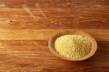 Lentils in a wooden bowl on rustic wooden background, top view, close-up, selective focus.