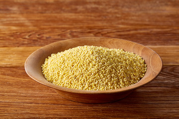 Lentils in a wooden bowl on rustic wooden background, top view, close-up, selective focus.