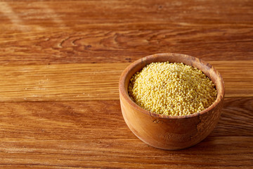 Lentils in a wooden bowl on rustic wooden background, top view, close-up, selective focus.