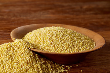 Lentils in a wooden bowl on rustic wooden background, top view, close-up, selective focus.