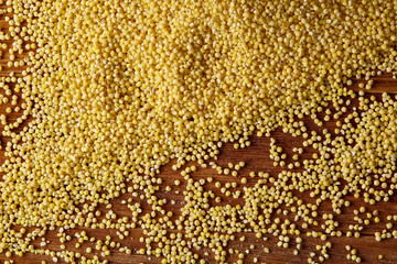 Lentils in a wooden bowl on rustic wooden background, top view, close-up, selective focus.