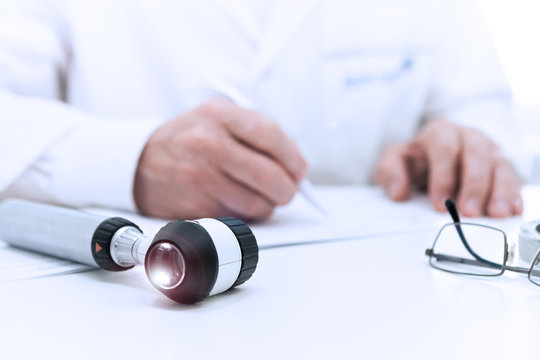 The doctor prescribers, amid Dermatoscope lying on the table