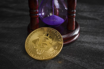 Coin in the form of bitcoin near the hourglass