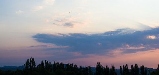 Landscape with dramatic light - beautiful golden sunset with saturated sky and clouds.