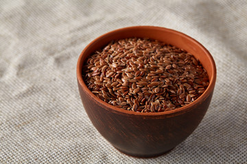 Bowl full of buckwheat grains on rustic wooden table, close-up, selective focus, shallow depth of field.