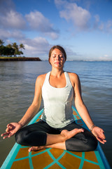 Fototapeta na wymiar Pretty young woman in meditation on the water at Ala Moana state park Oahu Hawaii
