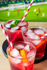 aperitif in the sports bar during a football match: Negroni cocktail with Campari, ice and orange slices, green and black olives