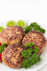 Homemade cutlets with parsley on a white plate and white background..shallow DOF
