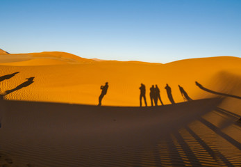 Fototapeta na wymiar Shadows of group tourists in curve of dune of Hidden Vlei, Sossusvlie Namibia