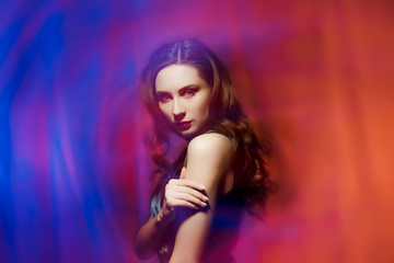 Fototapeta na wymiar Portrait of beautiful girl on blue and red background