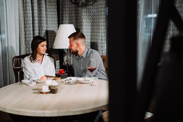 Couple of young beautiful people is sitting in a restaurant.