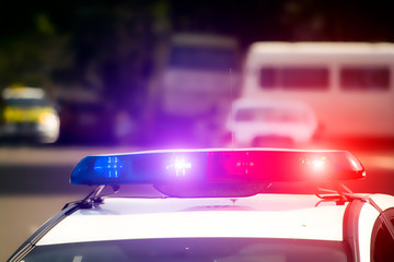 The blinkers of a police car on a blurred background. Blue and red flashing light. Danger. Crimes. The criminal world. © Valentin Kundeus