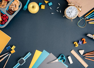 Top view of various school supplies on black background with copy space. Time to school concept.
