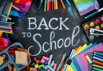 A bunch of various colorful school and art supplies with chalk lettering. Top view.