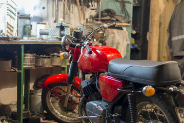 Fototapeta na wymiar Red vintage motorcycle parked in the garage