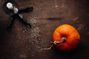 pumpkin and candlestick on a dark wooden background