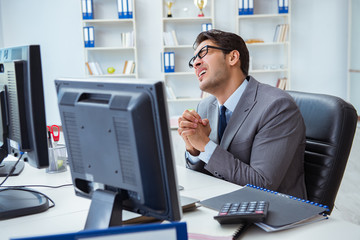 Businessman sitting in front of many screens