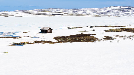 Remote mountain cabin by a frozen lake. Location lake Batstjone in Buskerud, Norway.