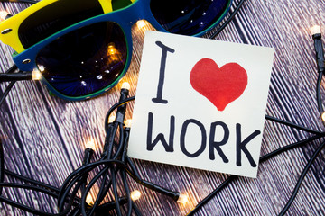 I love work Heart handwritten on a white paper with black color and a heart shape in red. A wooden...