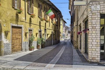 Lake Maggiore, Angera, Italy. Characteristic and picturesque alley (street - via Greppi) crosses the historic core of the village. Angera is known for the fortress of Angera (rocca di Angera)