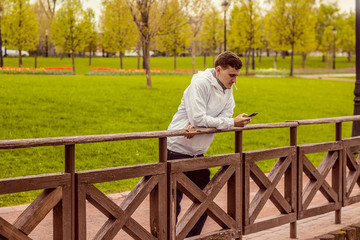 Молодой парень стоит на мосту, мужчина смотрит в...